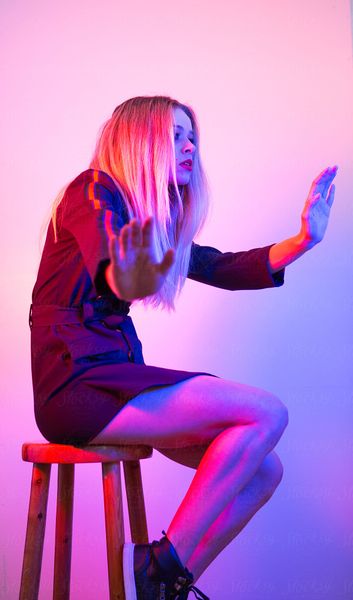 Attractive young woman photographed under strong pink and blue lighting