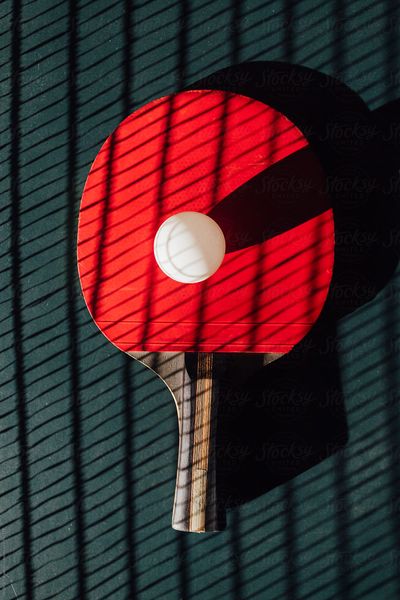 Red ping pong racket with ball
