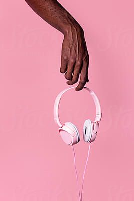 Hand holding pink headphones by ADDICTIVE CREATIVESfor Stocksy United