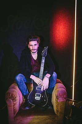 Portrait of Guitarist Holding Electric Guitar  by Luminafor Stocksy United