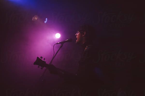 Singer and guitarist on stage during a live concert by simonfor Stocksy United