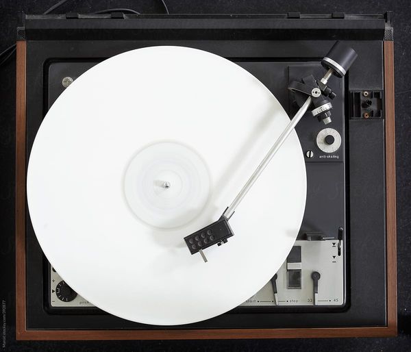 Vintage turntable with a white vinyl album turning