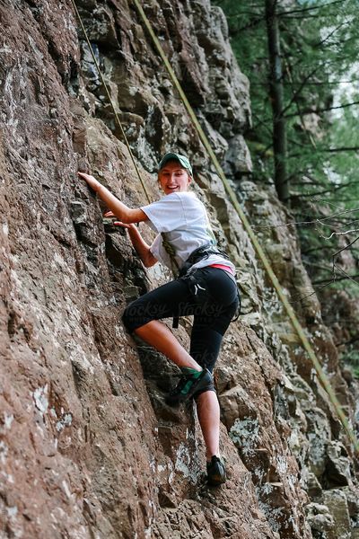 Smiling young woman rock climbing