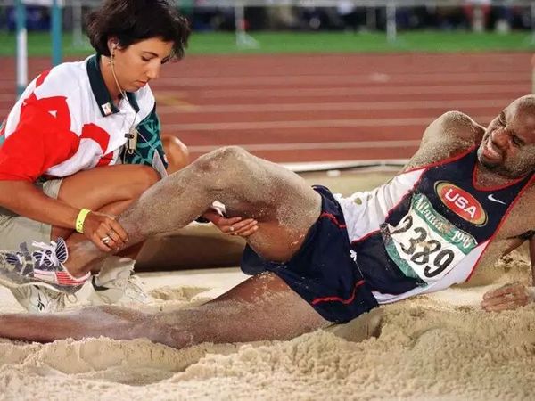 an-aide-attends-to-mike-powell-after-he-injured-himself-on-his-final-attempt-t