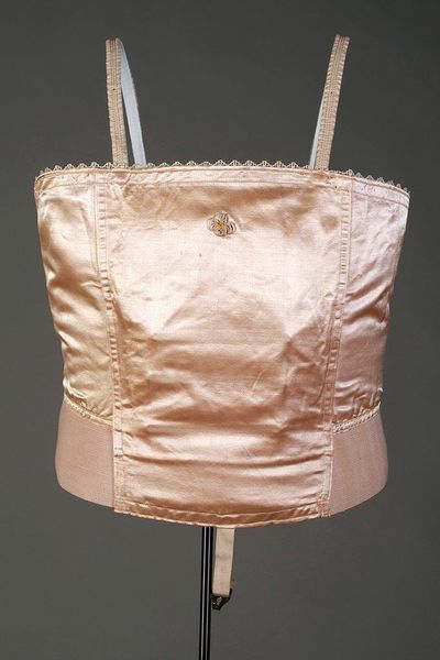Pink silk and elastic brassiere stiffened with 4 horizontal rows of steel across front, American, c…