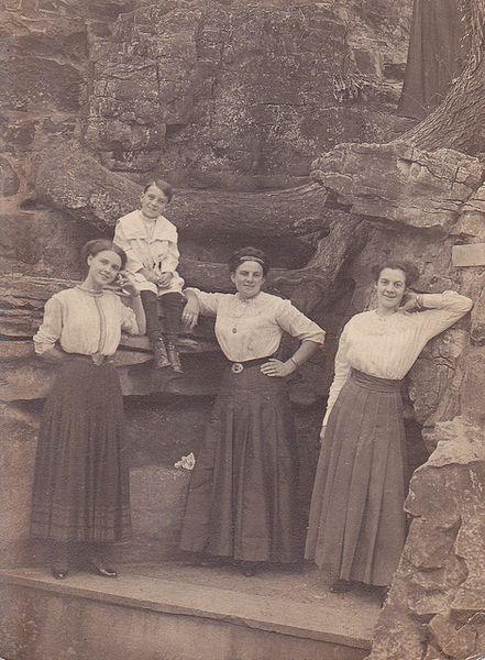 Three Edwardian sisters and their brother (they strongly resemble each other) pose in front a rock …