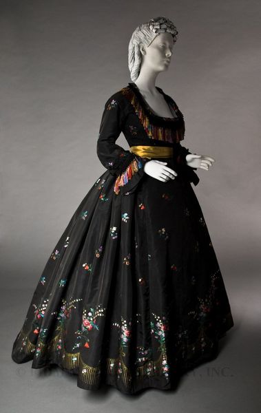 This black silk faille two-piece dress was worn by an unknown woman in approximately 1866. Though i…