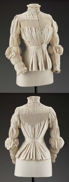 Ivory pleated blouse with a V-shaped smocked bib at the bustline front, back, and shoulder caps. Hi…