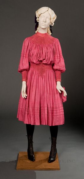 A bright pink girl’s dress made between 1893 and 1897 by Liberty & Co. of London, one of the grea…
