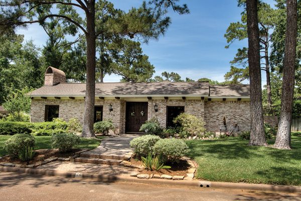 The ranch-style home is surrounded by mature trees.