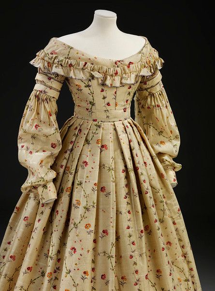 This 1830s day dress is made of challis printed with a realistic design of wild strawberries, bambo…