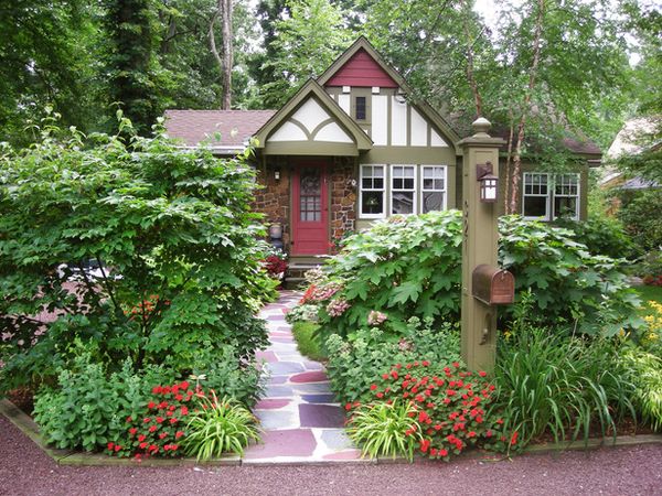 Charming Entry!!  The plantings around the front walk allow only a peek at the cottage-style home. …
