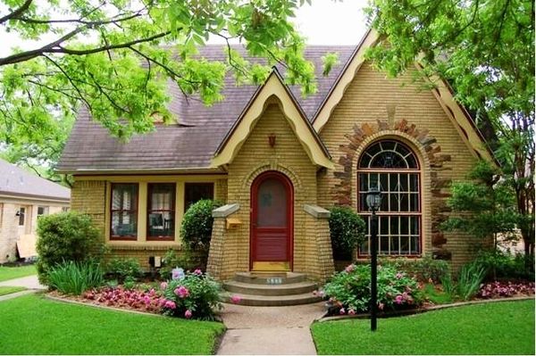 Charming small brick house with burgundy front door and rounded windows