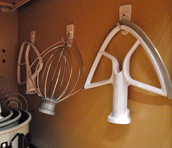 Hang mixer attachments inside cupboards.....on command hooks.  Great idea!