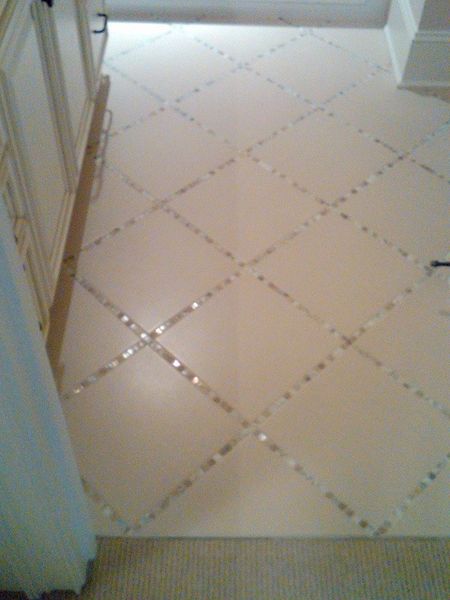 Lay a thin strip of "backsplash" tile in between the large tiles, instead of just using grout. *sim…