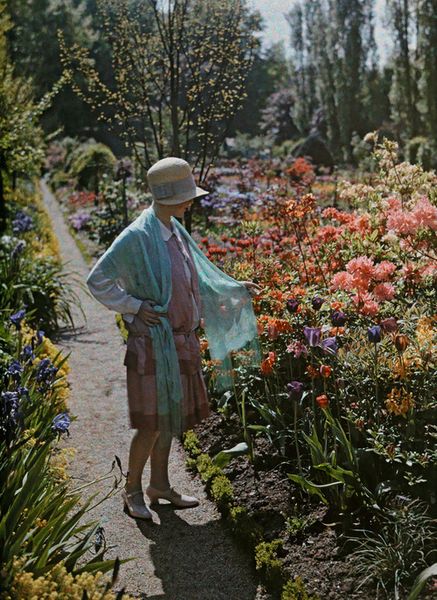 A young woman admires flowers in a Baden garden in Germany, June 1928. Photograph by Wilhelm Tobien…