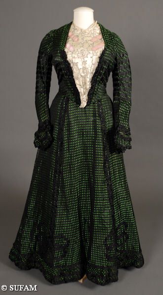 Woman's electric green and black dress, ca. 1900. Fabric is a novelty open weave trimmed with black…