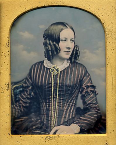 ca. 1850’s, [gorgeous hand-tinted daguerreotype portrait of a young woman posed in front of a clo…