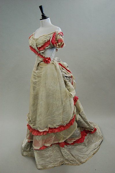 Circa 1870 grey moire taffeta ball gown trimmed with pink silk with pointed front bodice; the polon…